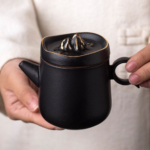 side view of gilded black mountain lid japanese teapot