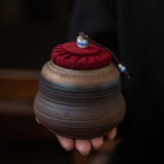 Handcrafted brown spiral japanese ceramic tea storage canister with red fabric lid