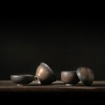 collection of handcrafted gilded japanese tea bowls on wooden tea tray