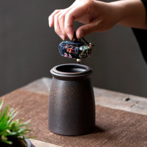 Handcrafted Japanese airtight ceramic tea canister with navy floral cloth lid