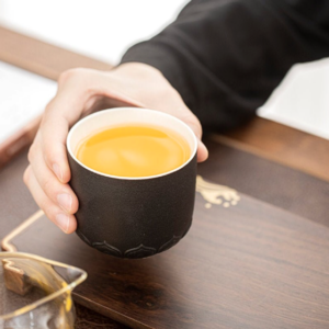 japanese black porcelain tea cup with lotus embossed base top view