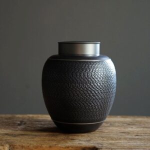 full product view of textured black japanese ceramic tea canister with airtight metal lid