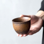 Japanese handcrafted iron rust glaze ceramic tea cup 5oz on wooden tea table
