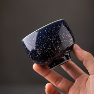 handcrafted japanese kiln transformation ceramic tea cup with speckled glaze and green interior