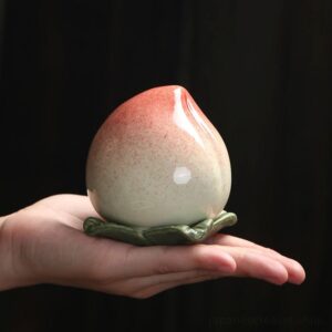 japanese peach shaped ceramic tea canister full view on dark background