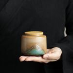 handcrafted japanese ceramic japanese tea canister with mountain relief and bamboo lid main view