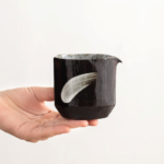 Handheld view of Japanese wabi-sabi handmade 5oz ceramic fairness cup tea pitcher