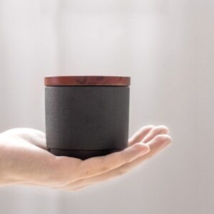 handheld view of japanese tea canister with wooden lid